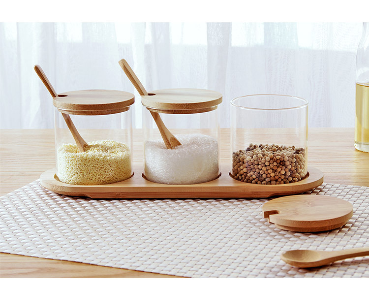 A 3-piece glass spice set with a spoon and a wooden lid