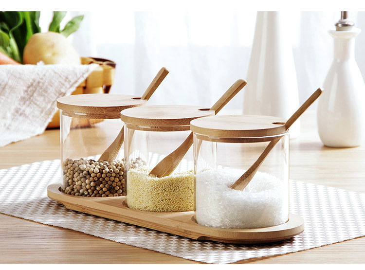 A 3-piece glass spice set with a spoon and a wooden lid